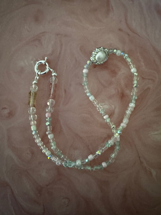 Beaded necklace on a textured pink surface