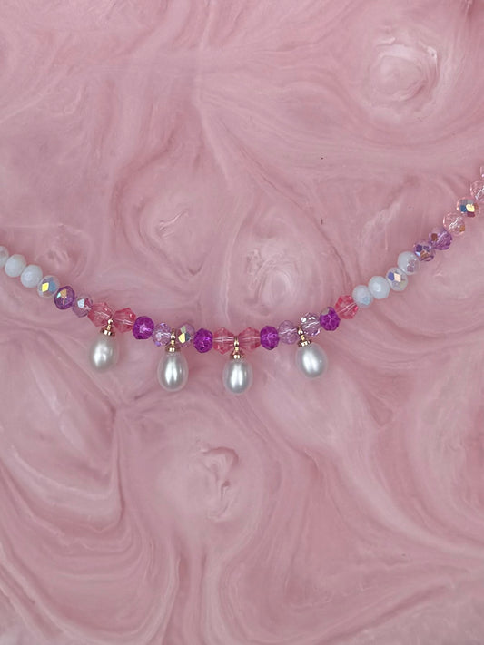 Necklace with beads on a pink marbled background