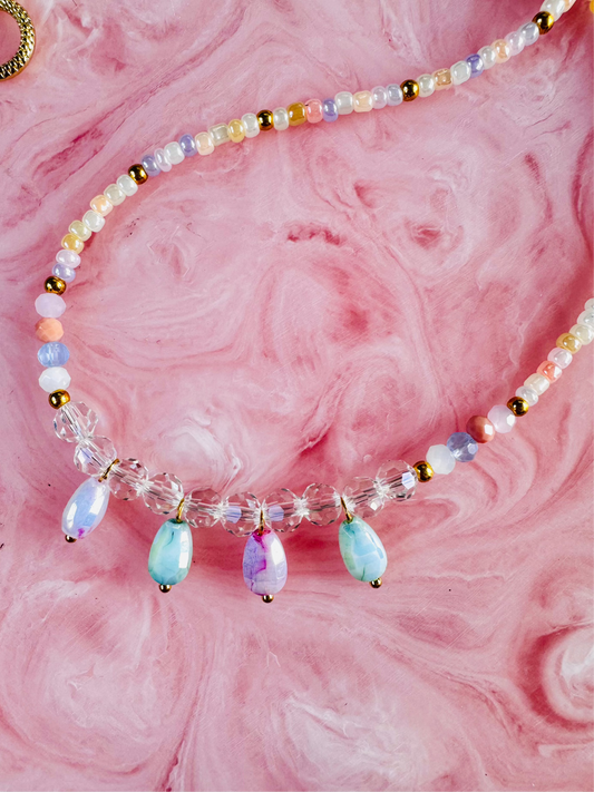 Beaded necklace with multicolored beads on a pink textured background
